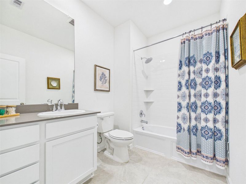 This bathroom, located in the hallway between the two secondary bedrooms, offers space and storage.