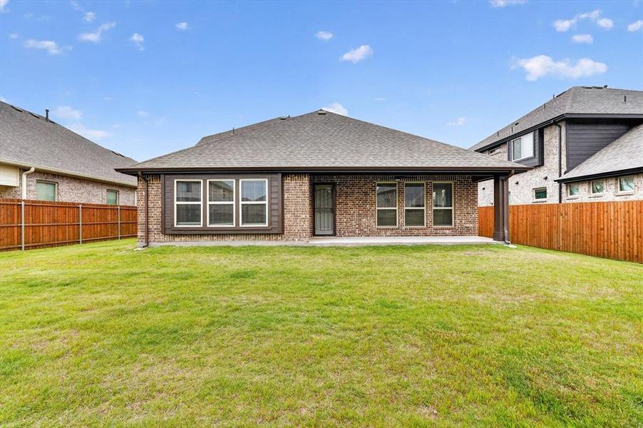 Expansive green lawn bordering a brick exterior with multiple windows Expansive green lawn bordering a brick exterior with multiple windows