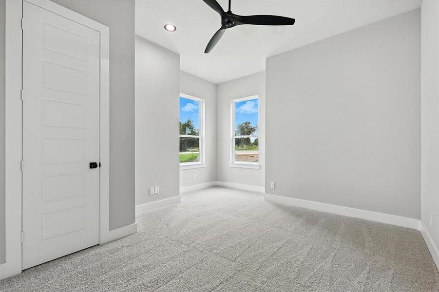 Carpeted empty room featuring a ceiling fan and recessed lighting Carpeted empty room featuring a ceiling fan and recessed lighting
