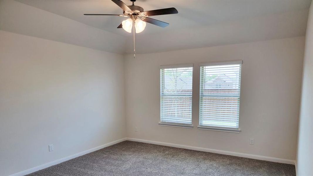 Carpeted spare room with baseboards and ceiling fan Carpeted spare room with baseboards and ceiling fan