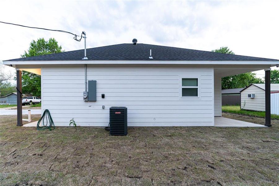 Rear view of property featuring a yard, central air condition unit, and a shingled roof Rear view of property featuring a yard, central air condition unit, and a shingled roof