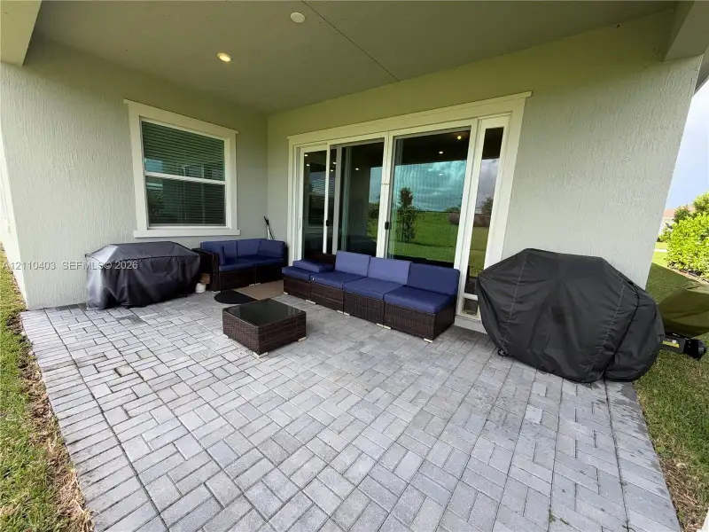 Covered patio featuring paver flooring, recessed lighting, and multi-panel sliding glass doors