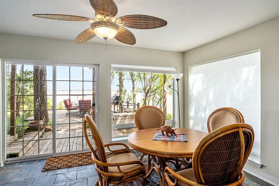 Dining area featuring large sliding glass doors, a transom window, and a modern ceiling fan with integrated lighting