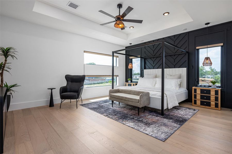 The primary suite is expansive and inviting with optional wood paneling, tray ceiling, designer fan, and an abundance of natural light—your dream retreat The primary suite is expansive and inviting with optional wood paneling, tray ceiling, designer fan, and an abundance of natural light—your dream retreat