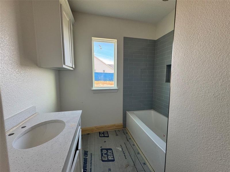 Bathroom featuring vanity and tiled shower / bath combo