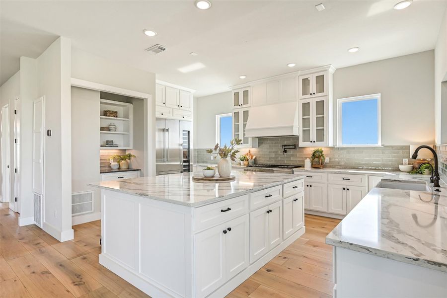 From this angle, the kitchen comes alive with style and purpose. The oversized 8-foot custom island invites family and friends to gather, while the Thermador 6-burner range, Thermador refrigerator, matching Thermador full-size wine fridge, and farmhouse sink make every culinary moment effortless. Cooking here isn’t a chore—it’s a joyful experience surrounded by breathtaking views that are truly to die for!