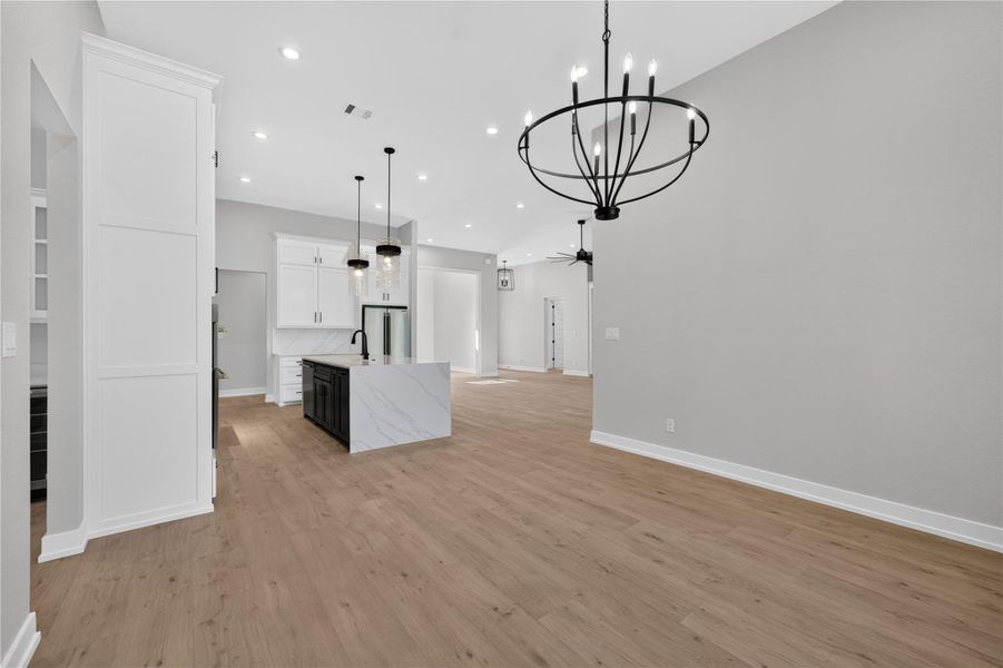 Clean lines and warm wood floors define this expansive open-concept living space.
