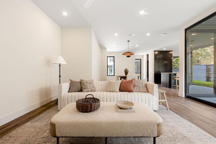 Living area with light wood finished floors and recessed lighting Living area with light wood finished floors and recessed lighting
