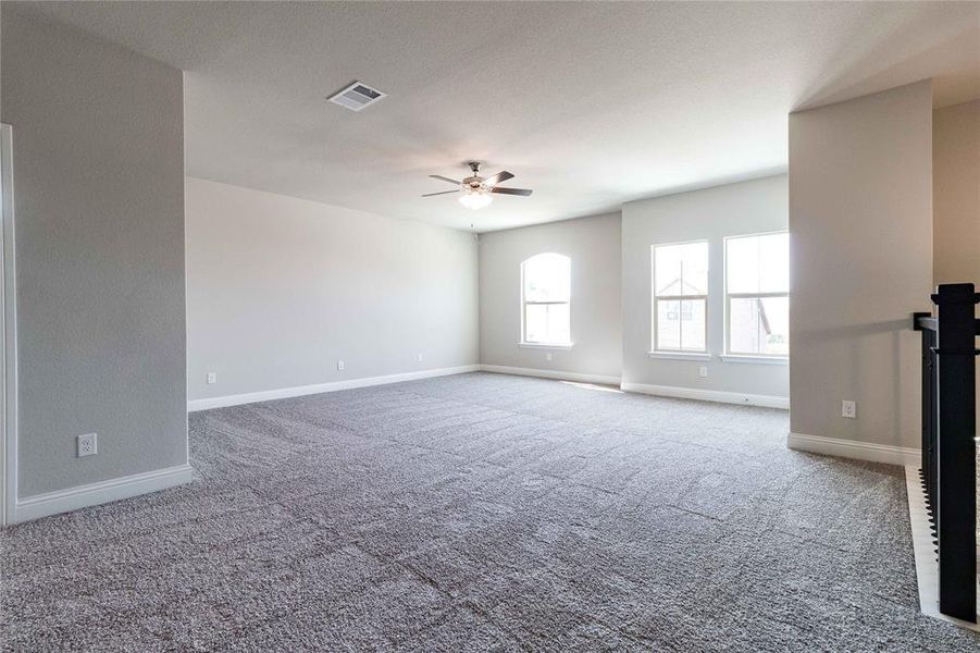 Unfurnished living room featuring ceiling fan and carpet