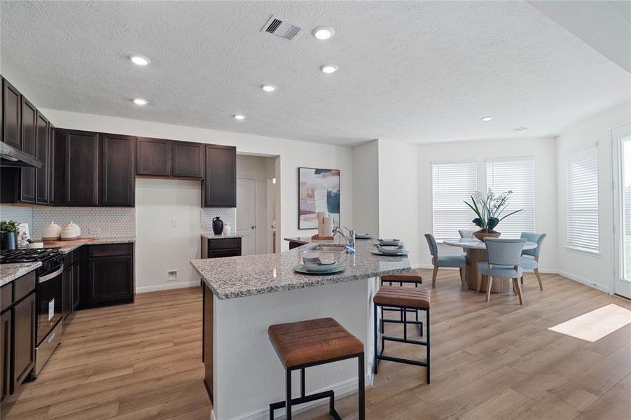 View of this beautiful large kitchen, kitchen island with extended countertop and breakfast nook.