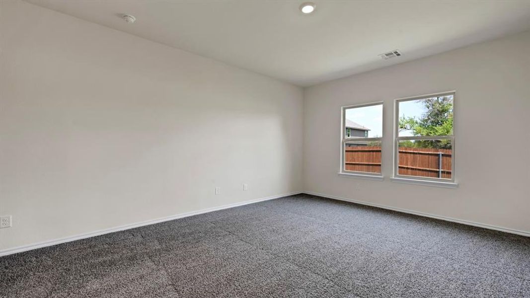 Spacious room featuring neutral-toned walls, plush carpet flooring, recessed ceiling lighting, and two double-pane windows