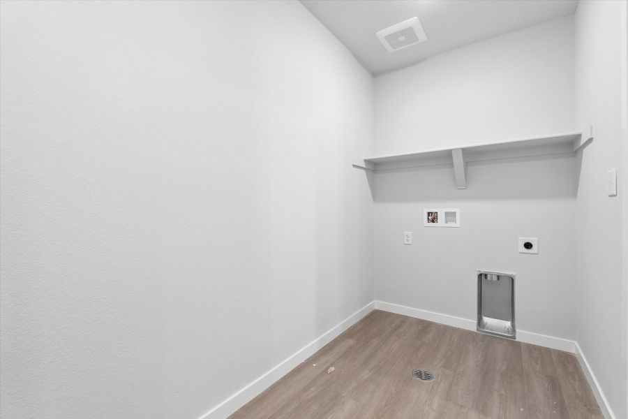 A room with a wood floor and a shelf with a speaker. A room with a wood floor and a shelf with a speaker.