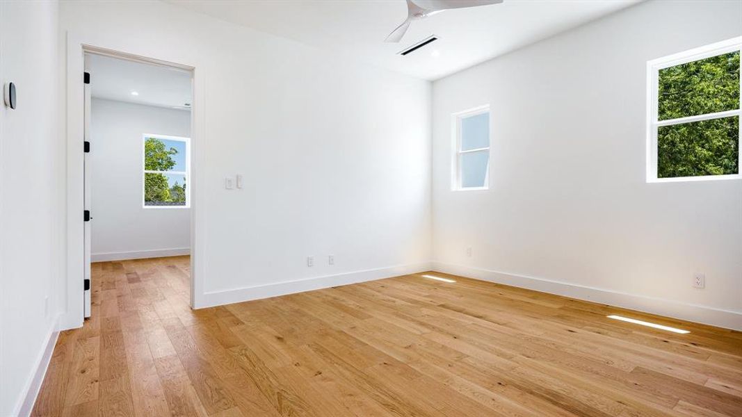 Empty room with light wood-type flooring and ceiling fan