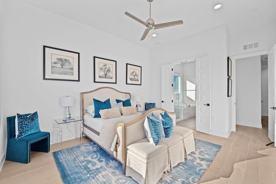 Bedroom featuring light wood finished floors, recessed lighting, ceiling fan, and ensuite bath Bedroom featuring light wood finished floors, recessed lighting, ceiling fan, and ensuite bath