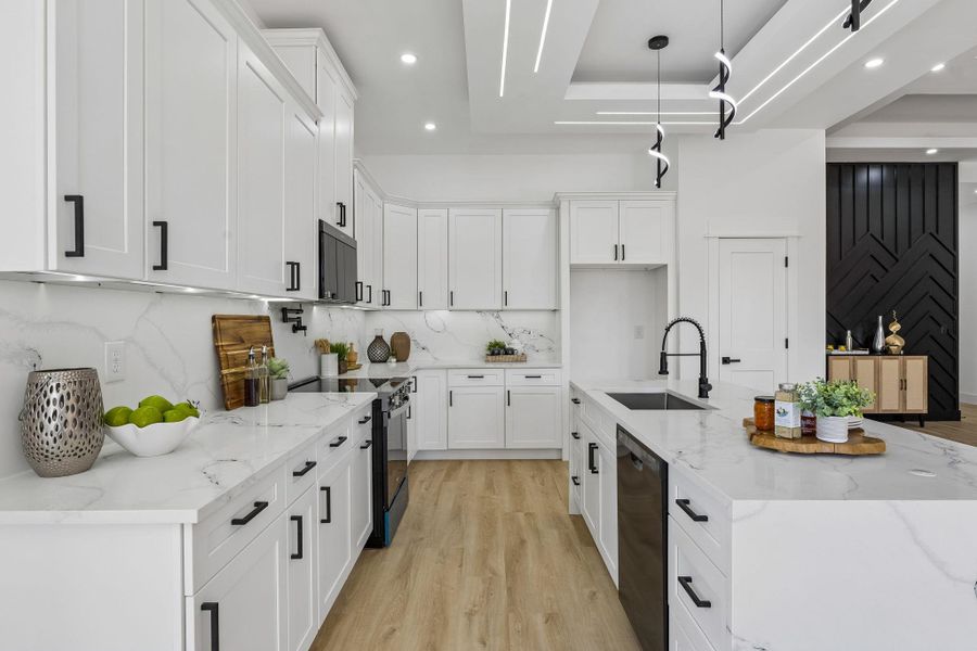 Sleek modern cabinetry and stone countertops anchor this light-filled contemporary kitchen.