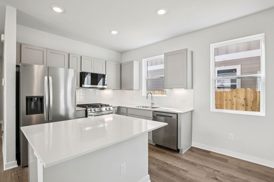 A kitchen with white cabinets.