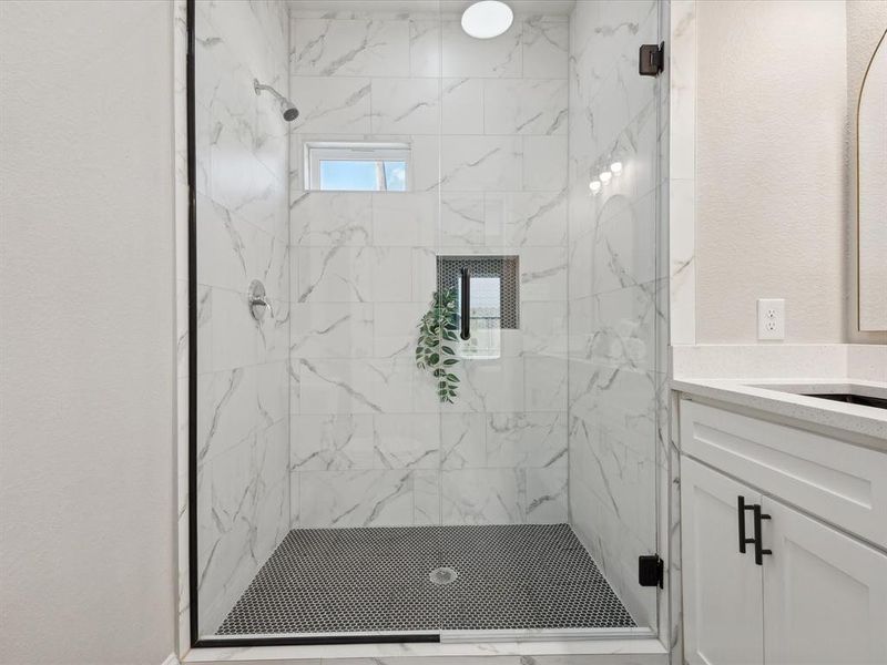 Bathroom featuring walk in shower and vanity