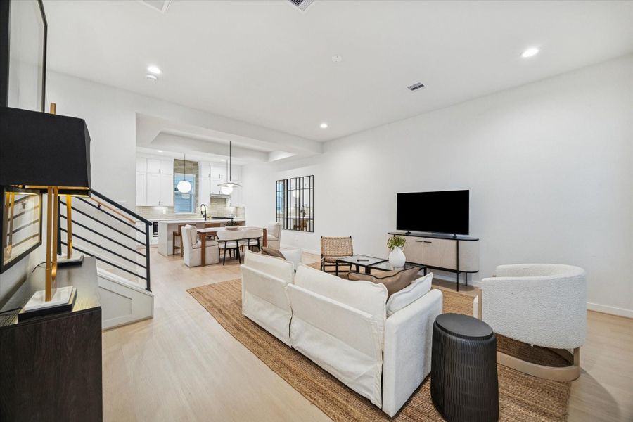 Open-concept living and dining area offers seamless flow and abundant natural light. Clean lines, neutral tones, and light wood floors create a bright, modern atmosphere that connects effortlessly to the kitchen for relaxed entertaining. Open-concept living and dining area offers seamless flow and abundant natural light. Clean lines, neutral tones, and light wood floors create a bright, modern atmosphere that connects effortlessly to the kitchen for relaxed entertaining.