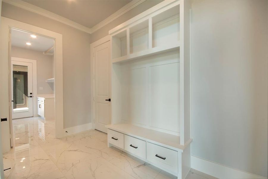 Mudroom featuring light marble finish flooring, ornamental molding, and recessed lighting Mudroom featuring light marble finish flooring, ornamental molding, and recessed lighting