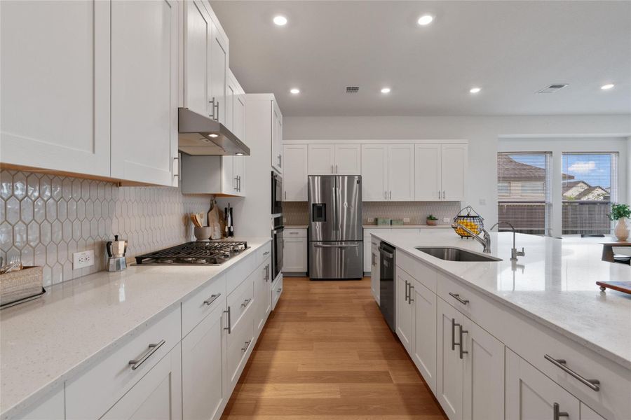 Culinary delights await in this bright kitchen, showcasing abundant cabinet storage and gleaming stainless steel appliances.