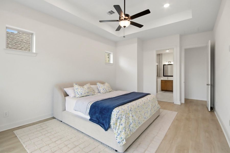 Comfortable bedroom featuring a cozy bed, contemporary ceiling fan, and private en-suite bathroom, creating a peaceful retreat for everyday living.