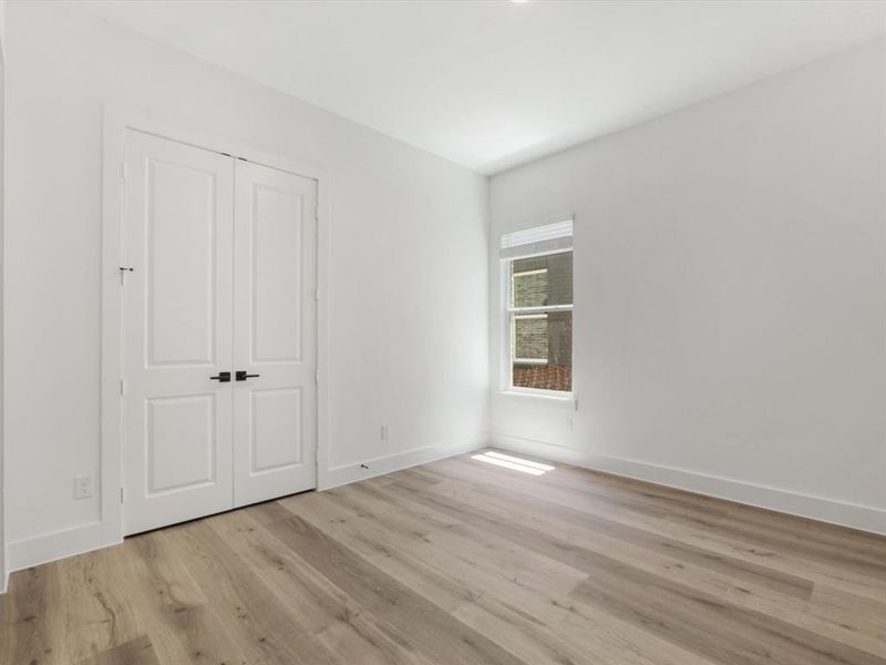 Downstairs Mother in law suite with ensuite bath featuring light wood finished floors and a closet