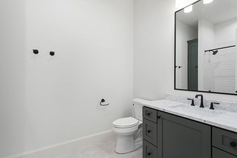Full bath with light tile patterned flooring, vanity, and a shower