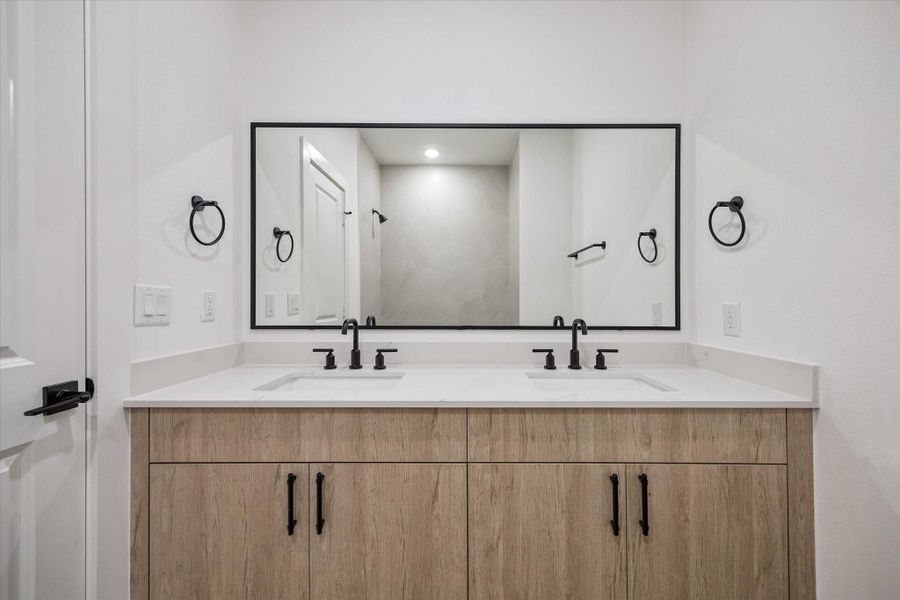 Elegant dual vanity with sleek fixtures and designer lighting Elegant dual vanity with sleek fixtures and designer lighting