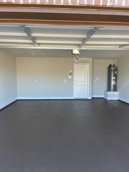 Garage featuring water heater and a garage door opener