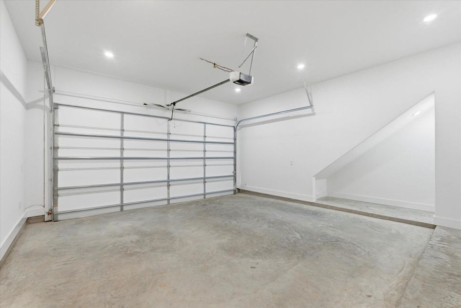An attached garage features an insulated door, automatic opener, and a convenient storage nook for added functionality.