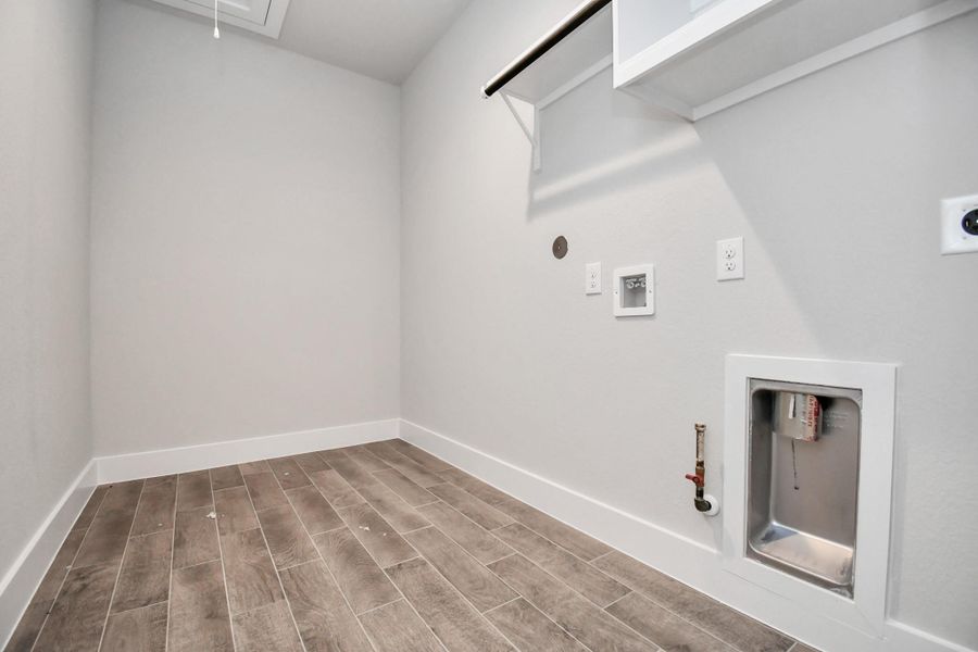 A perfect blend of functionality and comfort. Capture the essence of easy living with a first-floor laundry room, thoughtfully equipped with shelving for effortless organization. Both electric and gas connections available. Sample photo of completed home with similar floor plan. Actual colors and selections may vary. A perfect blend of functionality and comfort. Capture the essence of easy living with a first-floor laundry room, thoughtfully equipped with shelving for effortless organization. Both electric and gas connections available. Sample photo of completed home with similar floor plan. Actual colors and selections may vary.