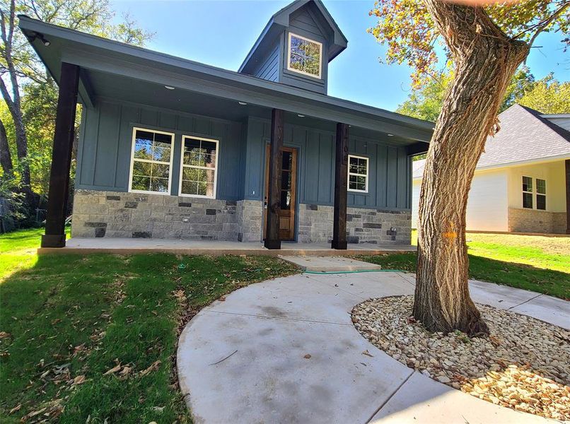 View of front of house with a porch and a front lawn