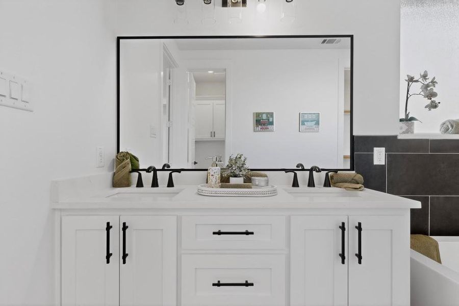 Full bathroom with double vanity, a bath, and tile walls Full bathroom with double vanity, a bath, and tile walls