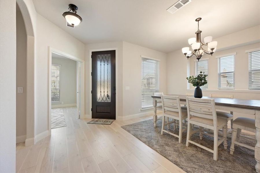 Handsome wood & glass, 8 foot front door and natural tone engineered wood floors. Dining area has an inviting chandelier and lots of natural light. The study is to the left of the front door.