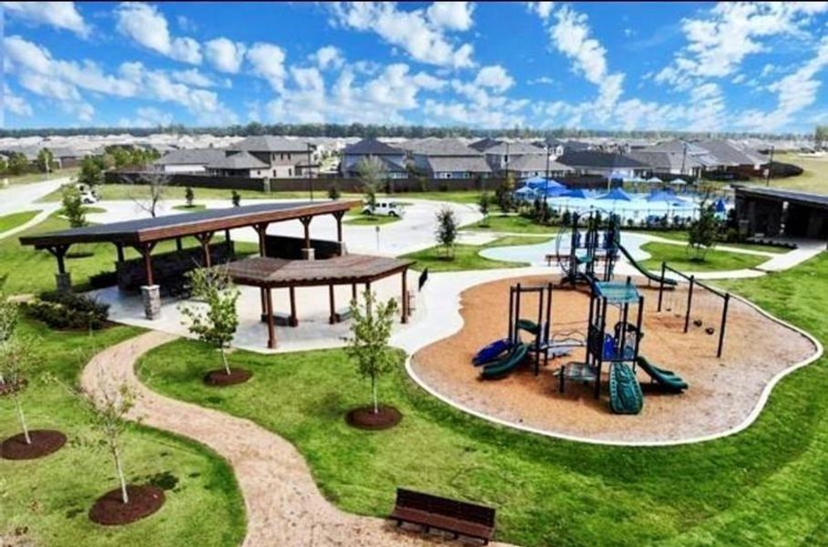 Surrounded by soft, well-maintained turf and shaded seating areas, it features colorful slides, climbing structures, swings, and interactive play zones designed for all ages.