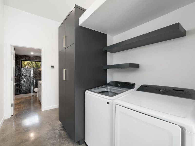 Laundry area with finished concrete floors and separate washer and dryer