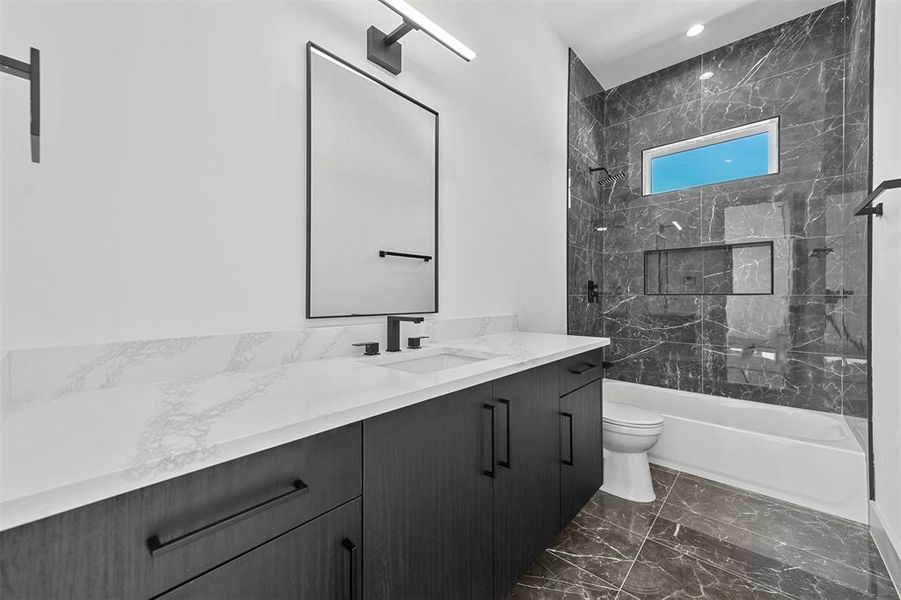 Full bathroom featuring tiled shower / bath combo, tile patterned floors, toilet, and vanity