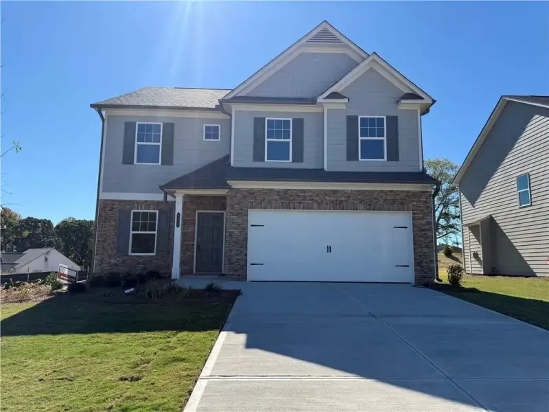 Front exterior of a new home in Falls Creek, Flowery Branch, GA, highlighting curb appeal (Image 1). Front exterior of a new home in Falls Creek, Flowery Branch, GA, highlighting curb appeal (Image 1).