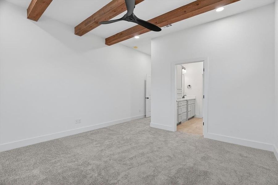 Spacious room featuring exposed wood ceiling beams and a contemporary black ceiling fan