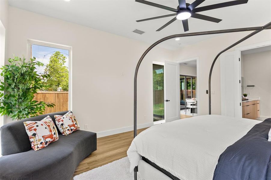Bedroom featuring wood-finish flooring, a modern ceiling fan, and white walls