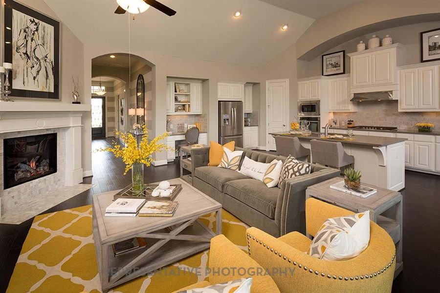 Living room with arched walkways, vaulted ceiling, a fireplace, recessed lighting, and a ceiling fan Living room with arched walkways, vaulted ceiling, a fireplace, recessed lighting, and a ceiling fan