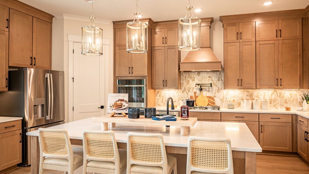 Gourmet kitchen with tile backsplash, pendent lighting, and elongated island Gourmet kitchen with tile backsplash, pendent lighting, and elongated island