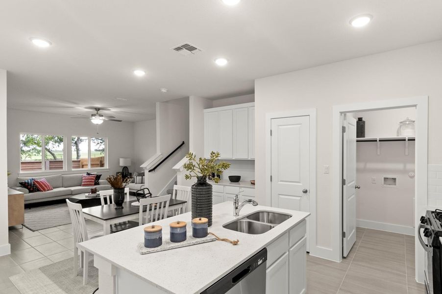 An open-concept living area boasts a modern kitchen with a large island and seamless flow into the dining and living spaces.