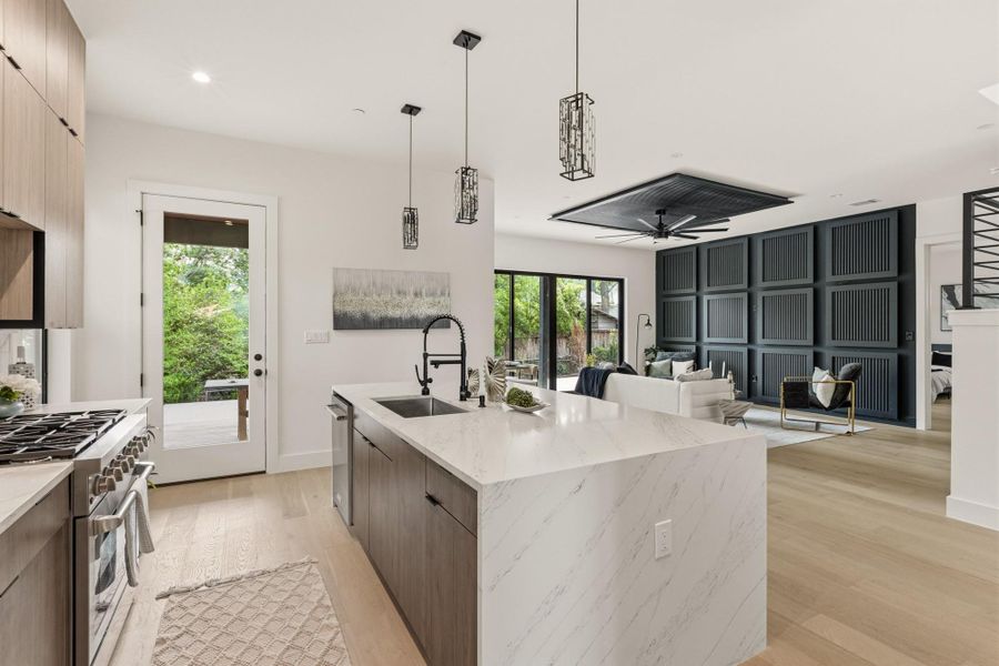 Kitchen island with waterfall countertop, integrated sink, and black matte faucet