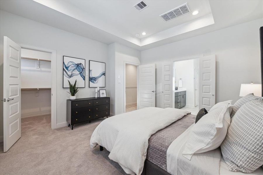 This alternate view of the spacious primary bedroom highlights the large walk-in closet and direct access to the ensuite bathroom. The ensuite features another convenient walk-in closet, providing ample storage and organization space.