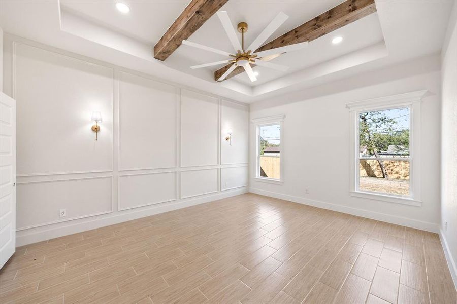Empty room with a decorative wall, beamed ceiling, wood tiled floors, recessed lighting, and ceiling fan