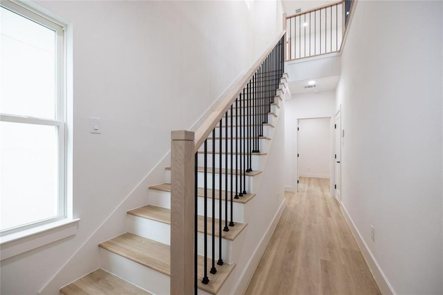 Wood-like LVP flooring extends seamlessly throughout, adding warmth and sophistication to every room. Wrought iron black balusters enhance the staircase with a touch of timeless elegance.