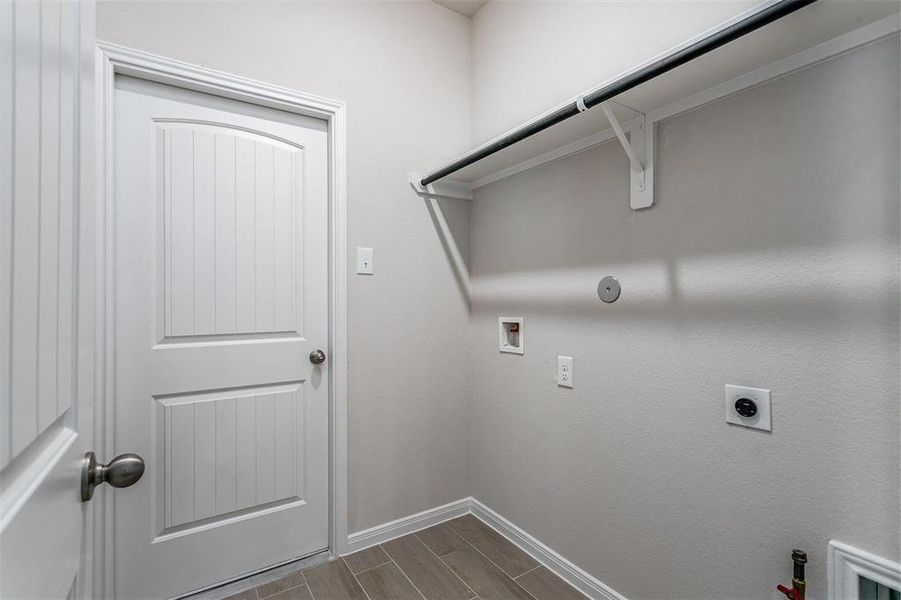 Conveniently located, the laundry room provides ample space for all your laundry needs. With dedicated hookups for both a washer and dryer, along with additional hanging space, this room is both practical and well-planned, making household chores a breeze. **This image is from another Saratoga Home - Mockingbird floorplan.**