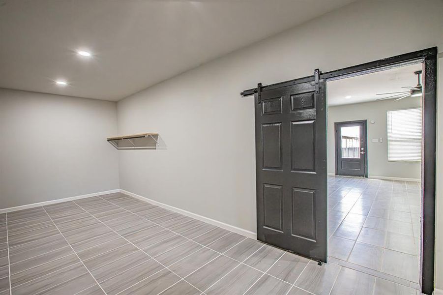 Unfurnished room with recessed lighting, a barn door, baseboards, and a ceiling fan