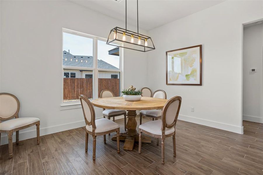 Dining area featuring a wealth of natural light, wood-type flooring, and an inviting chandelier